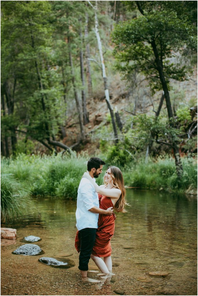 couples hold each other in oak creek waters for their oak creek canyon engagement photos