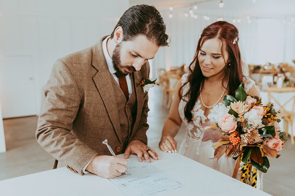 bride and groom sign marriage license after wedding ceremony