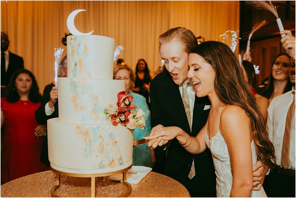 bride and groom cut the cake at reception ceremony