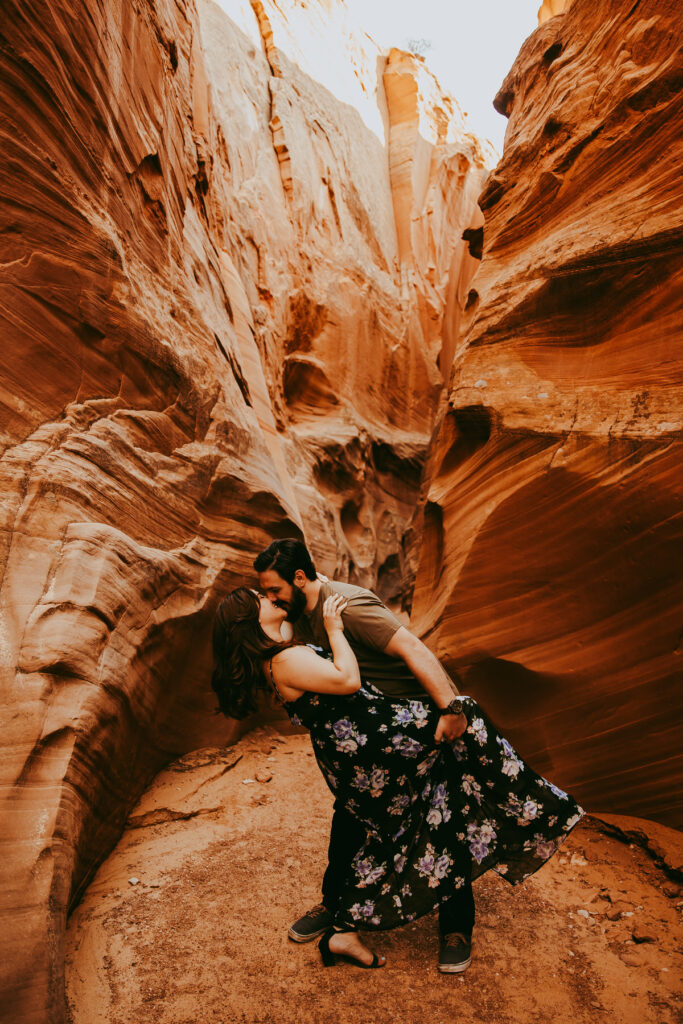 a man dips a woman in a dress and kisses her in Secret Antelope Canyon