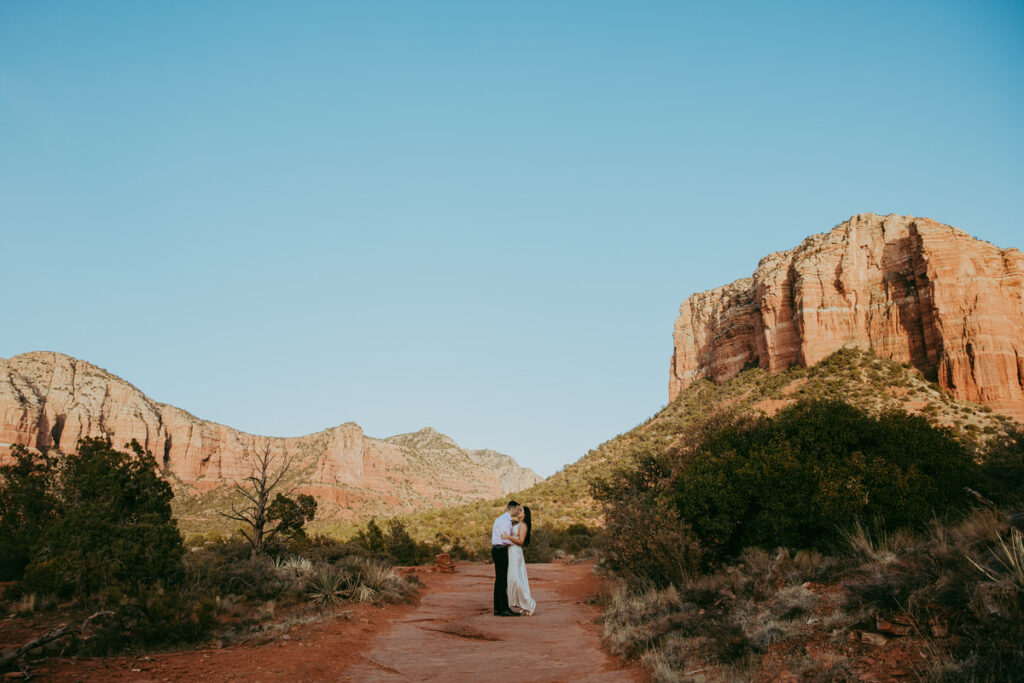 A man and woman kiss while embracing at Courthouse Vista for their Sedona engagement photos