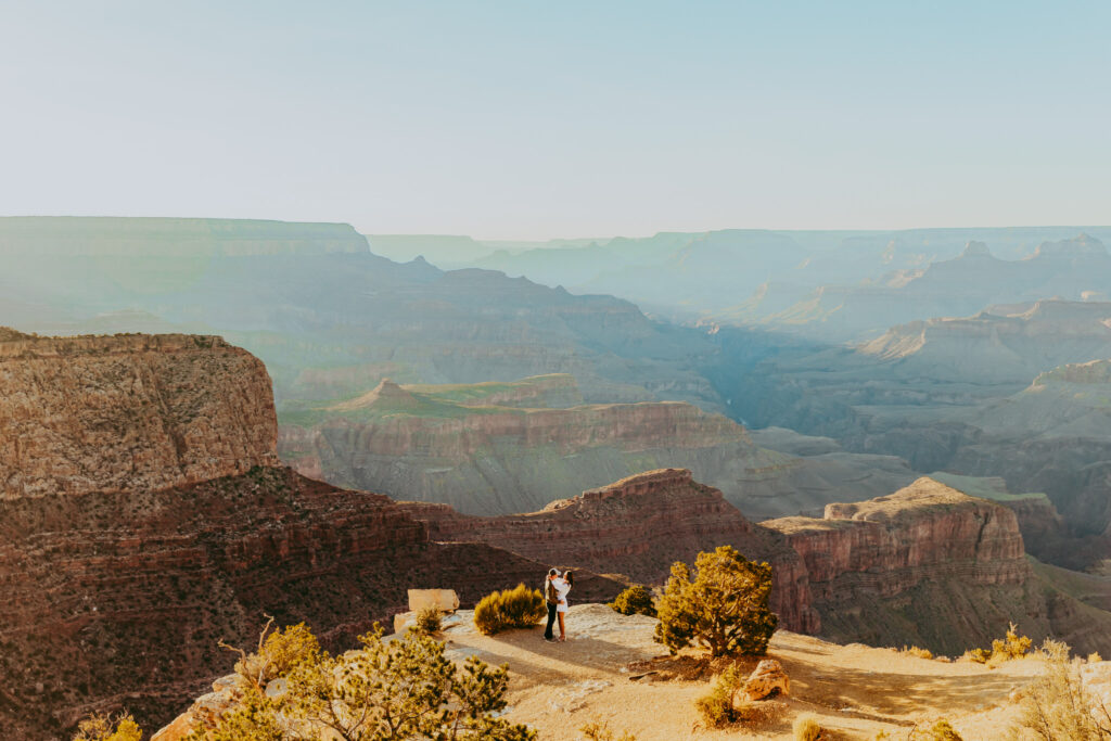 man and woman stand on the edge of the grand canyon 