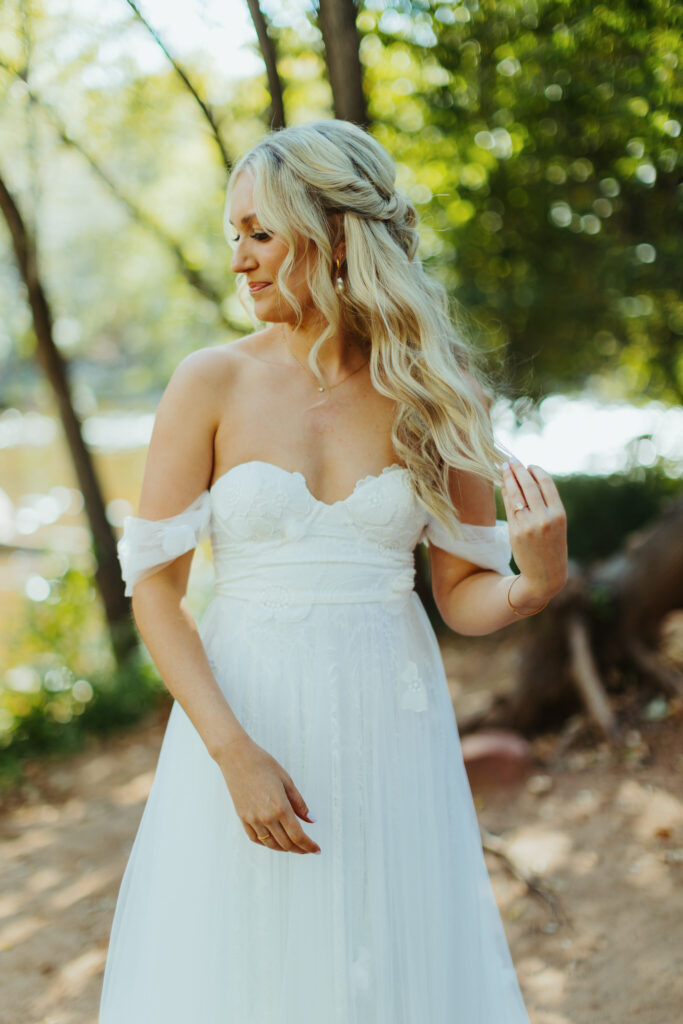 a stunning bride tossles her blonde hair while looking down her strapless dress