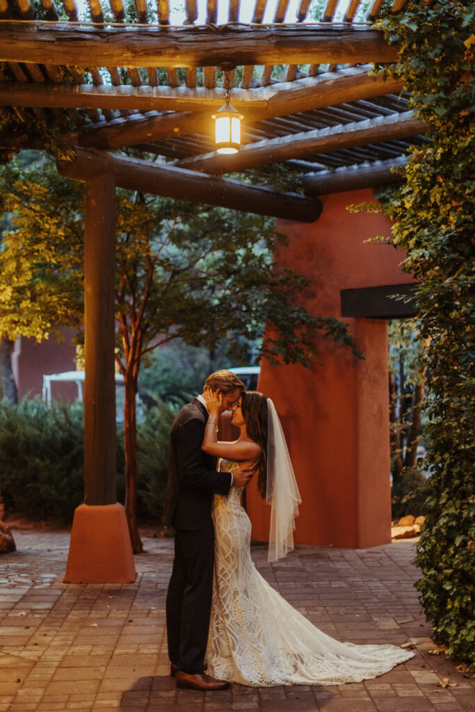 bride wearing wedding dress with veil holds her husband as they slow dance at enchantment resorts sedona arizona