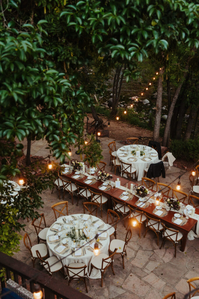 looking down on an intimate reception dinner set up with elegant table settings, chairs, and mood lighting