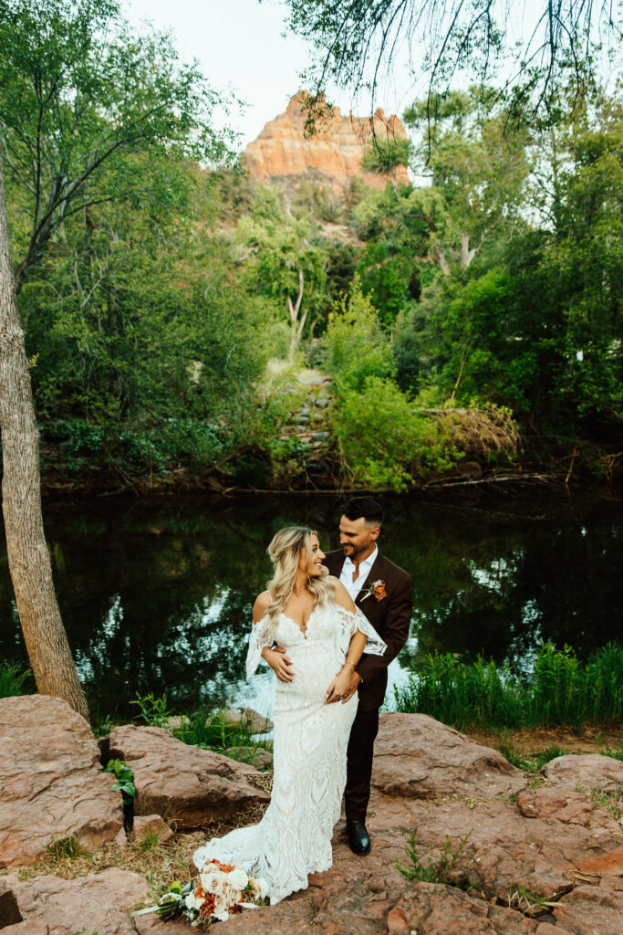 groom and pregnant bride post for bridal photos in sedona arizona near oak creek at amara resort