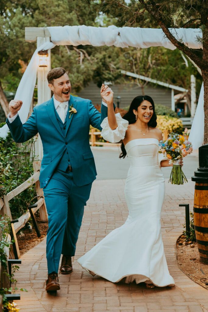bride and groom smiling as they enter their wedding reception