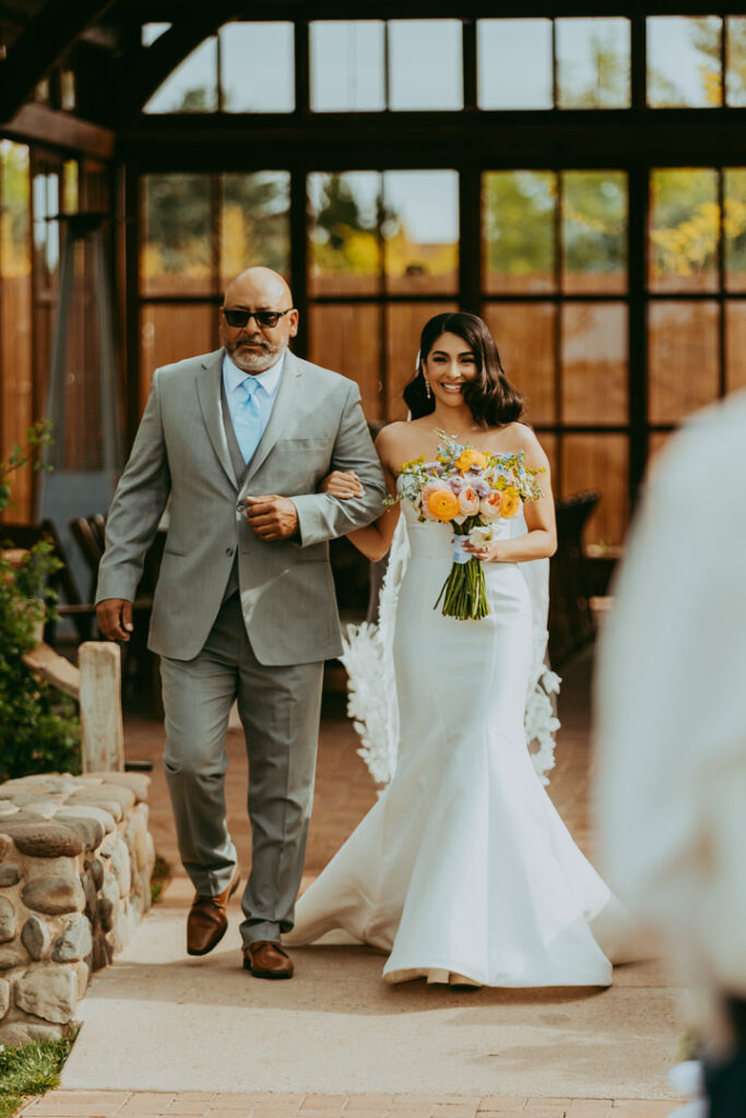 bride and father walking down the aisle at a wedding at sky ranch lodge