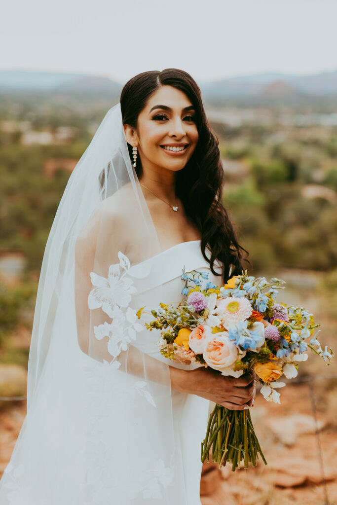 gorgeous bride standing with flowers in sedona arizona