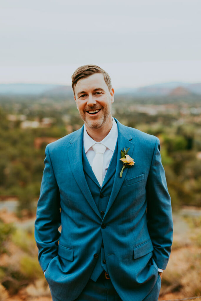 groom smiling in blue suite in sedona arizona