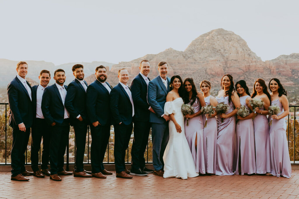 bridal party standing with sunset behind them in sedona arizona