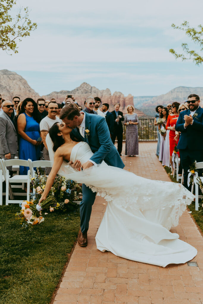 bride and groom sharing a kiss with a dip at the end of the aisle