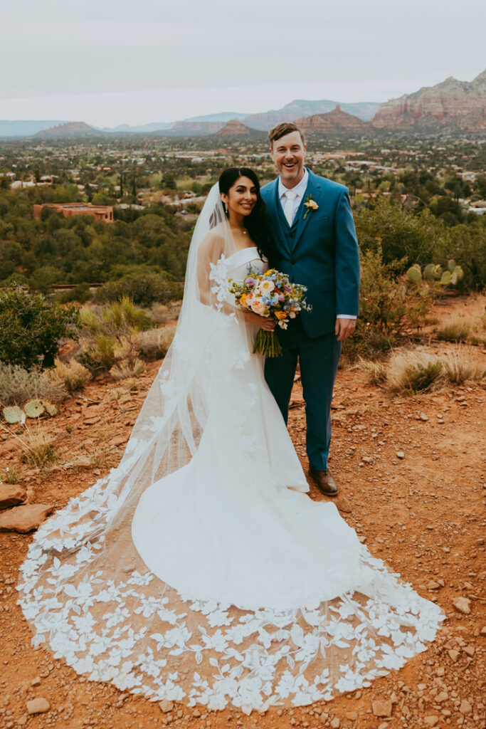 bride and groom standing together with flowers in sedona