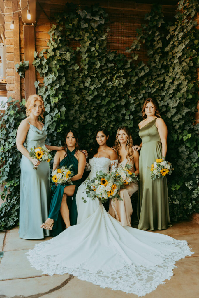 Bridal party poses for photos with ivy backdrop at agave of sedona. 